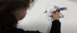 Image shows a pupil in an art class drawing a wolf